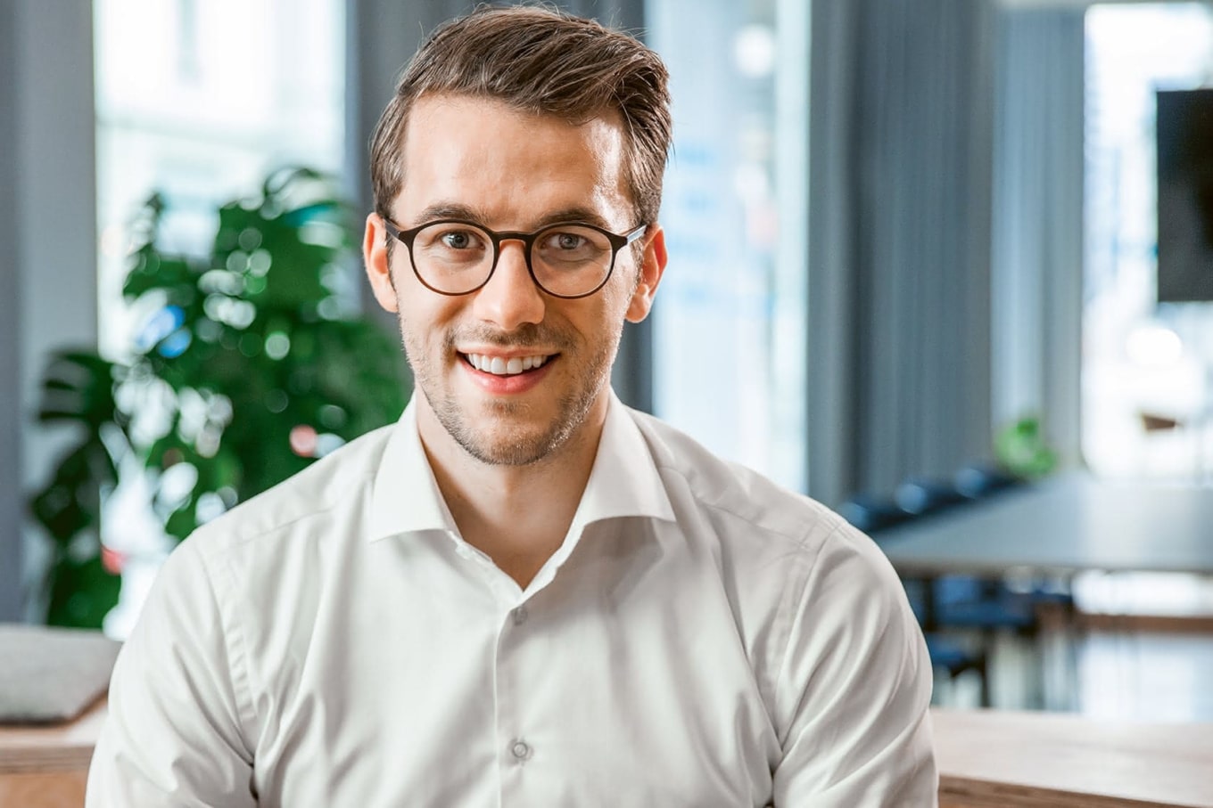 Lächelnder Mann mit Brille im Büro